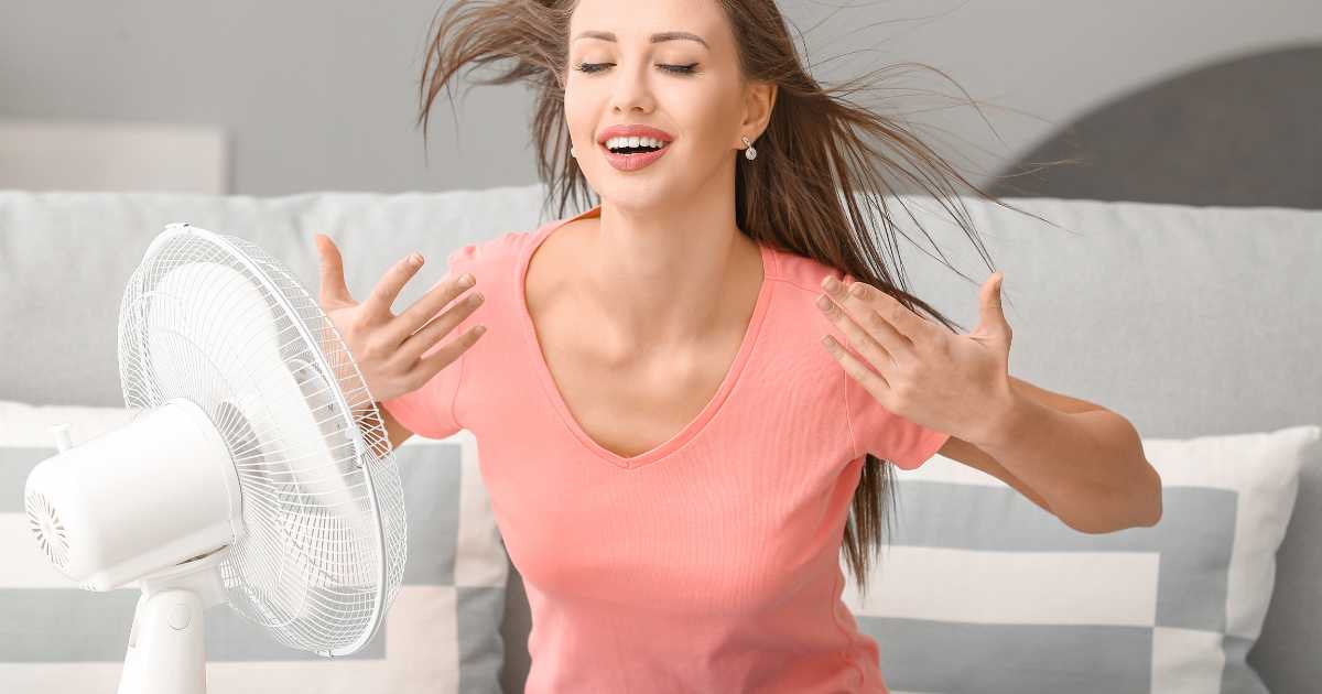 woman in front of electric fan