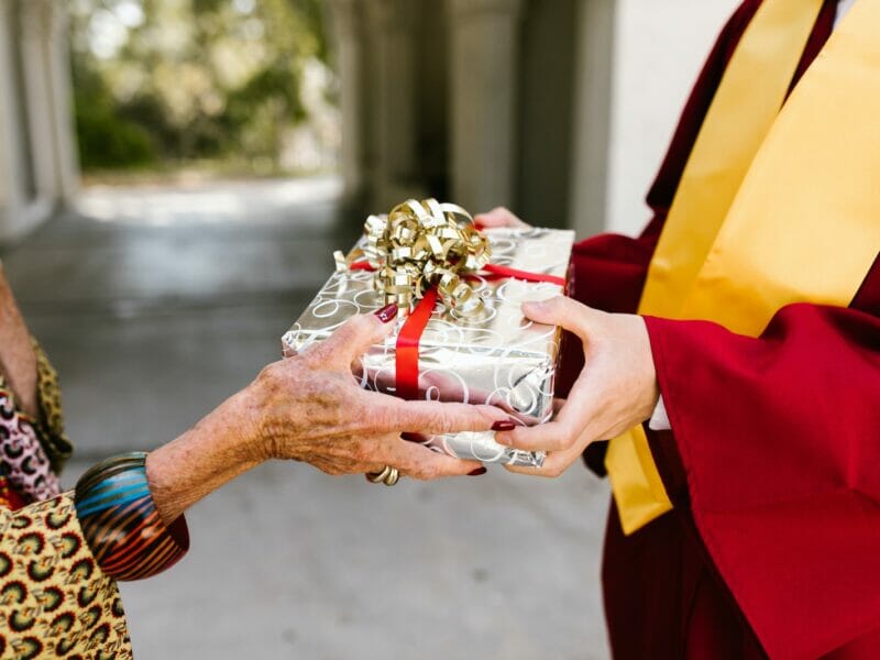 Elderly Hand Giving Graduation Gift
