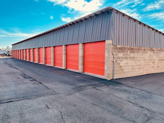 a storage building with red doors and a sky background